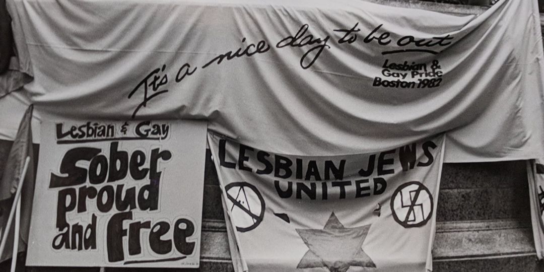 Signs reading It's a Nice Day To Be Out, Lesbian & Gay Sober Proud and Free and Lesbian Jews United Credit: Susan Fleischmann The History Project