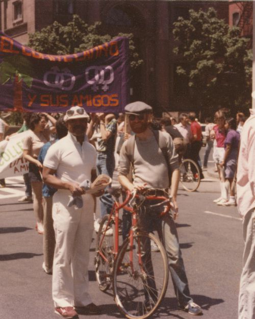 Two members of Black and White Men Together stand together at Boston Pride parade, 1984